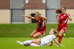 Nebraska Cornhuskers Sadie Waite (11) jumps over Maryland Terrapins defender Katie Coyle (9) doing a slide tackle in the first half during a college soccer match Thursday, October 12, 2023, in Lincoln, Neb. Photo by John S. Peterson.