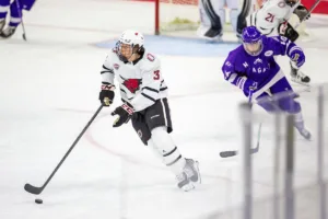 Omaha Mavericks defenseman Kirby Proctor (3) moves the puck down the ice against the Niagara Purple Eagles in the first period during a college hockey match on Friday, October 13, 2023, in Omaha, Nebraska. Photo by John S. Peterson.