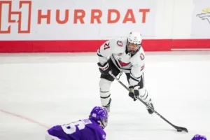 Omaha Mavericks forward Tyler Rollwagen (21) looks to pass against the Niagara Purple Eagles in the third period during a college hockey match on Friday, October 13, 2023, in Omaha, Nebraska. Photo by John S. Peterson.
