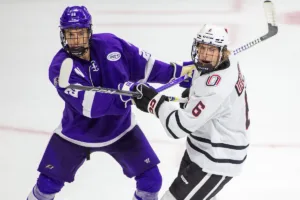 Omaha Mavericks forward Zach Urdahl (6) and Niagara Purple Eagles defenseman Ethan Lund (28) are battle out for position in the third period during a college hockey match on Friday, October 13, 2023, in Omaha, Nebraska. Photo by John S. Peterson.