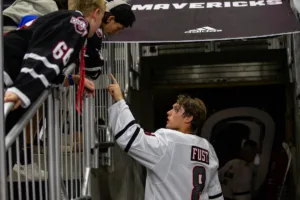 Omaha Mavericks forward Ray Fust (8) greets some young fans after the win against the Niagara Purple Eagles during a college hockey match on Friday, October 13, 2023, in Omaha, Nebraska. Photo by John S. Peterson.