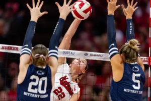 Nebraska Cornhusker Lindsay Krause (22) spikes the ball against Penn State Nittany Lions Allie Holland (20) and Mac Podraza (5) in the first set during a college volleyball match on Saturday, October 14, 2023, in Lincoln, Nebraska. Photo by John S. Peterson.