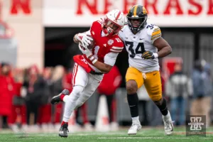 Nebraska Cornhuskers wide receiver Joshua Fleeks (11) runs for a extra yards after a catch past Iowa Hawkeyes linebacker Jay Higgins (34)during a game in Lincoln, NE November 24th 2023. Photo by Eric Francis