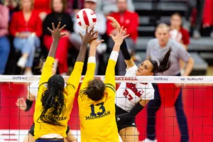 Nebraska Cornhusker Harper Murray (27) spikes the ball against Michigan Wolverine Serena Nyambio (1) and Valentina Vaulet (13) in the second set during the volleyball match on Friday, November 17, 2023, in Lincoln, Nebraska. Photo by John S. Peterson.