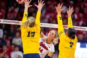 Nebraska Cornhusker Ally Batenhorst (14) spikes the ball against Michigan Wolverine Jacque Boney (17) and Morgan Burke (7) in the first set during the volleyball match on Friday, November 17, 2023, in Lincoln, Nebraska. Photo by John S. Peterson.