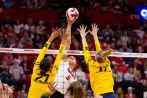 Nebraska Cornhusker Bekka Allick (5) spieks the ball against Michigan Wolverine Kendall Murray (27) and Jacque Boney (17) in the first set during the volleyball match on Friday, November 17, 2023, in Lincoln, Nebraska. Photo by John S. Peterson.