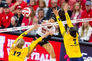 Nebraska Cornhusker Harper Murray (27) spikes the ball against Michigan Wolverine Morgan Burke (7) and Jacque Boney (17) in the third set during the volleyball match on Friday, November 17, 2023, in Lincoln, Nebraska. Photo by John S. Peterson.