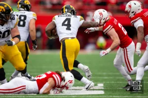 Nebraska Cornhusker defensive back Isaac Gifford (2) tackles Iowa Hawkeye running back Leshon Williams (4) in the third quarter during the football game on Thursday, November 24, 2023, in Lincoln, Neb. Photo by John S. Peterson.