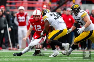 Nebraska Cornhusker quarterback Chubba Purdy (12) fumbles the football against Iowa Hawkeye linebacker Jay Higgins (34) in the fourth quarter during the football game on Thursday, November 24, 2023, in Lincoln, Neb. Photo by John S. Peterson.