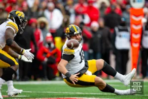 Iowa Hawkeye quarterback Deacon Hill (10) trips as he pitches the ball back in the fourth quarter against the Nebraska Cornhuskers   during the football game on Thursday, November 24, 2023, in Lincoln, Neb. Photo by John S. Peterson.