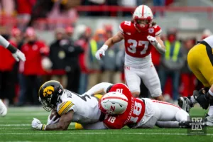 Nebraska Cornhusker defensive lineman Princewill Umanmielen (18) tackles Iowa Hawkeye running back Leshon Williams (4) in the fourth quarter during the football game on Thursday, November 24, 2023, in Lincoln, Neb. Photo by John S. Peterson.