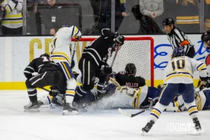 Omaha Maverick defenseman Jacob Guevin (10) (left) puts the puck in the goal in the second period against the Augustana Vikings  during the hockey match on Saturday, November 25, 2023, in Sioux Falls, SD. Photo by John S. Peterson.