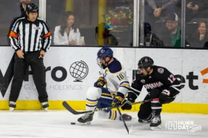 Augustana Viking forward Arnaud Vachon (10) and Omaha Maverick defenseman Nolan Krenzen (12) fight for the puck in the second period during the hockey match on Saturday, November 25, 2023, in Sioux Falls, SD. Photo by John S. Peterson.