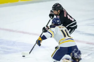 Omaha Maverick forward Ty Mueller (19) passes the puck against Augustana Viking forward Arnaud Vachon (10) in the second period during the hockey match on Saturday, November 25, 2023, in Sioux Falls, SD. Photo by John S. Peterson.