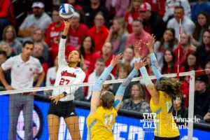 Nebraska Cornhusker Harper Murray (27) spikes the ball against Long Island Sharks Bria Plante (31) and Cristal Paulino Rubel (14) in the first set during the first round of the NCAA volleyball championships on Friday, December 1, 2023, in Lincoln, Neb. Photo by John S. Peterson.