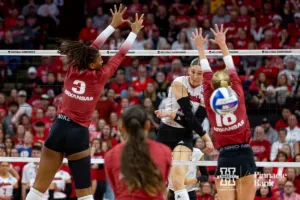 Nebraska Cornhusker Andi Jackson (15) spikes the ball against Arkansas Razorbacks Sania Petties (3) and Hannah Hogue (18) in the second set during the Regional Championship match in the NCAA Volleyball Championship Thursday, December 7, 2023, Lincoln, Neb. Photo by John S. Peterson.