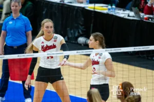 Nebraska Cornhuskers outside hitter Ally Batenhorst (14) and setter Bergen Reilly (2) give each other five in the first set during the NCAA Finals on Sunday, December 17, 2023, in Tampa, Florida. Photo by John S. Peterson.
