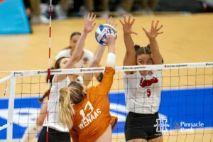 Nebraska Cornhuskers setter Bergen Reilly (2) and middle blocker Bekka Allick (5) jump to block Texas Longhorn outside hitter Jenna Wenaas (13) in the first set during the NCAA Finals on Sunday, December 17, 2023, in Tampa, Florida. Photo by John S. Peterson.