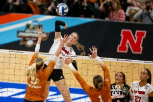 Nebraska Cornhusker middle blocker Andi Jackson (15) spikes the ball against Texas Longhorn middle blocker Bella Bergmark (5) and Texas Longhorn setter Ella Swindle (1) in the second set during the NCAA Finals on Sunday, December 17, 2023, in Tampa, Florida. Photo by John S. Peterson.