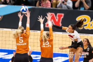 Nebraska Cornhusker outside hitter Harper Murray (27) spikes the ball against Texas Longhorn middle blocker Bella Bergmark (5) and opposite Molly Phillips (15) in the second set during the NCAA Finals on Sunday, December 17, 2023, in Tampa, Florida. Photo by John S. Peterson.