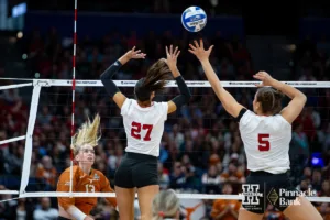 Nebraska Cornhusker outside hitter Harper Murray (27) and middle blocker Bekka Allick (5) jump to block Texas Longhorn outside hitter Jenna Wenaas (13) in the first set during the NCAA Finals on Sunday, December 17, 2023, in Tampa, Florida. Photo by John S. Peterson.