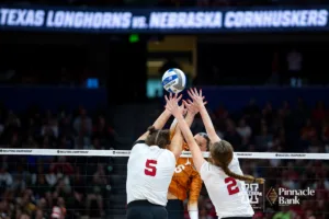 Nebraska Cornhusker middle blocker Bekka Allick (5) and setter Bergen Reilly (2) jump trying to block Texas Longhorn outside hitter Madisen Skinner (6) in the first set during the NCAA Finals on Sunday, December 17, 2023, in Tampa, Florida. Photo by John S. Peterson.