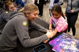 Gina Mancuso-Prososki signs her autograph for a little girl after the first professional volleyball match in the United States on Wednesday, January 24, 2024, in Omaha, Nebraska. Photo by John S. Peterson.