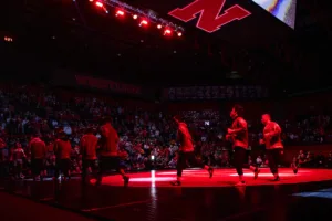 Nebraska Cornhuskers run out to the mat to take on Iowa Hawkeyes during a college wrestling march on Friday, January 12, 2024, in Lincoln, Nebraska. Photo by John S. Peterson.