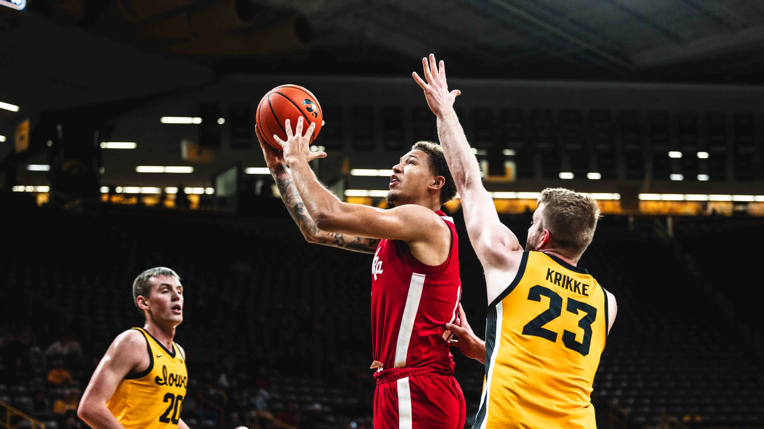 Nebraska freshman Eli Rice scores at the basket against a pair of Hawkeyes.