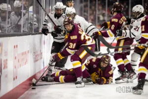Minn. Duluth defenseman Luke Bast (38) battles for the puck against Omaha in the first period during a college hockey match on Friday, February 2, 2024, in Omaha, Nebraska. Photo by John S. Peterson.