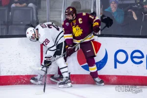 Omaha forward Jack Randl (28) and Minn. Duluth forward Luke Loheit (16) battles for the puck in the third period during a college hockey match on Friday, February 2, 2024, in Omaha, Nebraska. Photo by John S. Peterson.