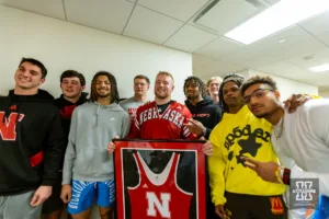 Nebraska Corhusker senior Nash Hutmacher poses for a photos with some of his football teammates during a college wrestling match against the Michigan Wolverines on Friday, February 9, 2024, in Lincoln, Nebraska. Photo by John S. Peterson.