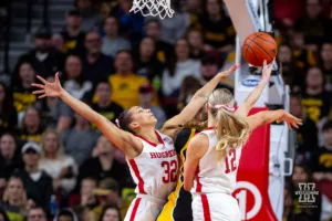 Nebraska Cornhusker guard Kendall Coley (32) and forward Jessica Petrie (12) reach out to block Iowa Hawkeye guard Kate Martin (20) in the first quarter during a college basketball game on Sunday, February 11, 2024, in Lincoln, Nebraska. Photo by John S. Peterson.
