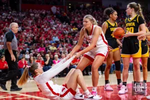 Nebraska Cornhusker forward Jessica Petrie (12) helps guard Kendall Moriarty (15) get up after being fouled in the second quarter against the Iowa Hawkeyes during a college basketball game on Sunday, February 11, 2024, in Lincoln, Nebraska. Photo by John S. Peterson.
