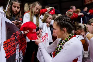 Nebraska Cornhusker guard Maddie Krull (42) signs a hat after a college basketball game against the Minnesota Golden Gophers Saturday, February 24, 2024, in Lincoln, Neb. Photo by John S. Peterson.