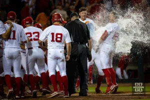 Nebraska Cornhusker Cole Evans (12) celebrates hitting a three-run homer in the tenth inning with a Gatorade bath at home for a walk-off win against the Indiana Hoosiers during an NCAA college baseball game Saturday, May 5, 2024, in Lincoln, Neb. Photo by John S. Peterson.