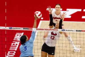 Nebraska Cornhusker Merritt Beason (13) jumps up to block a shot from Texas A&M CC Islander Tori Arrington (5) during the college volleyball game Friday, August 30, 2024, in Lincoln, Nebraska. Photo John S. Peterson.