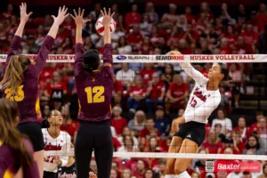 Nebraska Cornhusker Merritt Beason (13) spikes the ball against Arizona State Sundevil setter Argentina Ung (12) and Claire Jeter in the second set during the college volleyball match Friday, September 13, 2024, in Lincoln, Nebraska. Photo John S. Peterson.