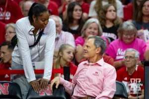 Former Husker Brianna Holman talks with head coach John Cook before the match against the Rutgers Scarlet Knights during a college volleyball match Saturday, October 12, 2024, in Lincoln, Nebraska. Photo by John S. Peterson.