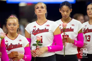 Nebraska Cornhuskers standing with pink roses for the Pink Out match against the Rutgers Scarlet Knights during a college volleyball match Saturday, October 12, 2024, in Lincoln, Nebraska. Photo by John S. Peterson.