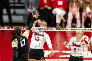 Nebraska Cornhusker Merritt Beason (13) spikes the ball against Purdue Boilermaker outside hitter Eva Hudson (17) during a college volleyball match Friday, October 11, 2024, in Lincoln, Nebraska. Photo by John S. Peterson.