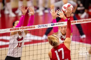 Nebraska Cornhusker Andi Jackson (15) and Merritt Beason jump up to block Rutgers Scarlet Knight outside hitter Avery Jesewitz (17) during a college volleyball match Saturday, October 12, 2024, in Lincoln, Nebraska. Photo by John S. Peterson.