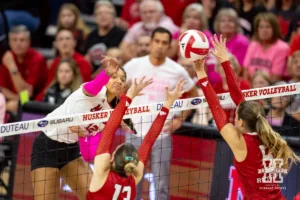 Nebraska Cornhusker Taylor Landfair (12) spikes the ball against Rutgers Scarlet Knight setter Aly Borellis (5) during a college volleyball match Saturday, October 12, 2024, in Lincoln, Nebraska. Photo by John S. Peterson.