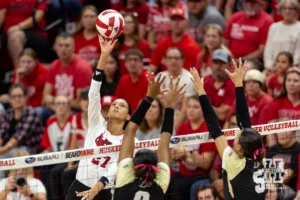 Nebraska Cornhusker Harper Murray (27) spikes the ball against Purdue Boilermaker middle blocker Lourdès Myers (9) and Taylor Anderson during a college volleyball match Friday, October 11, 2024, in Lincoln, Nebraska. Photo by John S. Peterson.