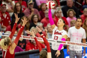 Nebraska Cornhusker Merritt Beason (13) spikes the ball against Rutgers Scarlet Knight outside hitter Avery Jesewitz (17) during a college volleyball match Saturday, October 12, 2024, in Lincoln, Nebraska. Photo by John S. Peterson.