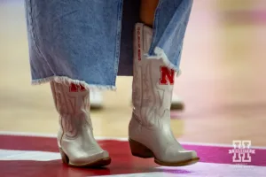 Nebraska Cornhusker assistant coach Jordan Larson wearing cowboy boots saying "Go Big Red" during a college volleyball match against the Purdue Boilermakers Friday, October 11, 2024, in Lincoln, Nebraska. Photo by John S. Peterson.