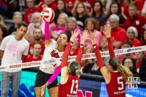 Nebraska Cornhusker Harper Murray (27) spikes the ball against Rutgers Scarlet Knight middle blocker Ece Emrullah (13) and Aly Borellis during a college volleyball match Saturday, October 12, 2024, in Lincoln, Nebraska. Photo by John S. Peterson.