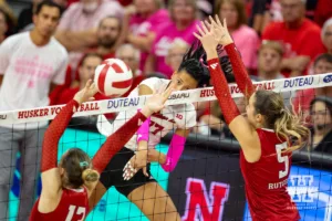 Nebraska Cornhusker Harper Murray (27) spikes the ball against Rutgers Scarlet Knight middle blocker Ece Emrullah (13) and Aly Borellis during a college volleyball match Saturday, October 12, 2024, in Lincoln, Nebraska. Photo by John S. Peterson.