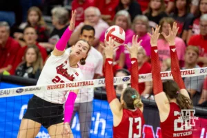 Nebraska Cornhusker Lindsay Krause (22) spikes the ball against Rutgers Scarlet Knight middle blocker Ece Emrullah (13) and Alissa Kinkela during a college volleyball match Saturday, October 12, 2024, in Lincoln, Nebraska. Photo by John S. Peterson.